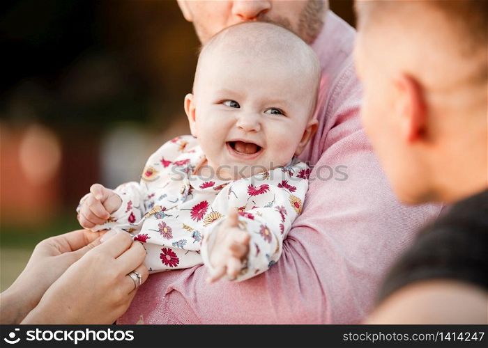 dad is holding little cute smiling daughter in arms. Family spending summer time together, outside, on vacation, outdoors on sunset. The concept of family holiday. dad is holding little cute smiling daughter in arms. Family spending summer time together, outside, on vacation, outdoors on sunset. The concept of family holiday.