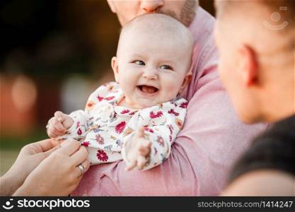 dad is holding little cute smiling daughter in arms. Family spending summer time together, outside, on vacation, outdoors on sunset. The concept of family holiday. dad is holding little cute smiling daughter in arms. Family spending summer time together, outside, on vacation, outdoors on sunset. The concept of family holiday.