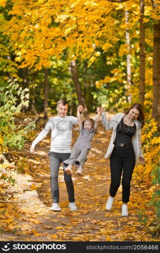 Dad, mom and daughter are walking in the autumn forest.. Autumn walk of a young family in the forest 3372.