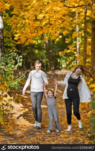 Dad, mom and daughter are walking in the autumn forest.. Autumn walk of a young family in the forest 3373.