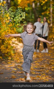 Dad, mom and daughter are walking in the autumn forest.. Autumn walk of a young family in the forest 3375.