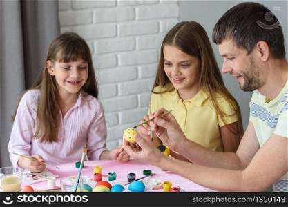 Dad shows children how to easily and easily paint Easter eggs