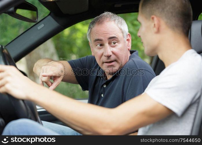 dad teaching his son to drive a car