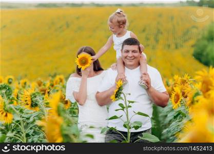 Daddy&rsquo;s carrying a baby daughter on his shoulders in the field of flowers. The concept of summer holiday. Father&rsquo;s, mother&rsquo;s, baby&rsquo;s day. Spending time together. Family look. selective focus.. Daddy&rsquo;s carrying a baby daughter on his shoulders in the field of flowers. The concept of summer holiday. Father&rsquo;s, mother&rsquo;s, baby&rsquo;s day. Spending time together. Family look. selective focus