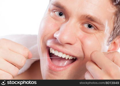 Daily health care. Young man cleaning flossing his white teeth with dental floss