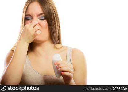 Daily skin care and hygiene. Funny girl covers her nose sweating, using stick deodorant. Young woman holding antiperspirant in hand on white