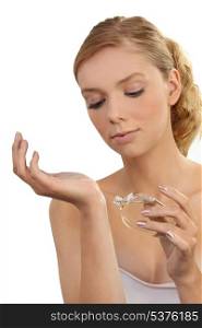 dainty young blonde putting on perfume