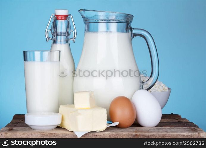 Dairy products assortment on old wooden table, blue background