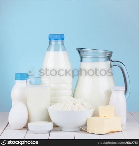 Dairy products assortment on wooden table, blue background