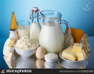 Dairy products, milk, cheese, egg, yogurt, sour cream, cottage cheese and butter on blue background still life