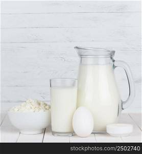 Dairy products. Milk, cottage cheese, egg and sour cream on white wooden table