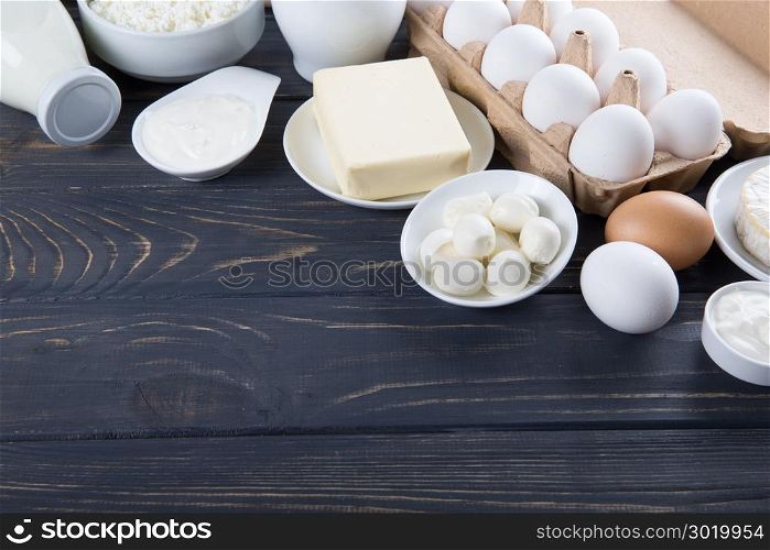 Dairy products on wooden table. Milk, cheese, egg, curd cheese and butter.