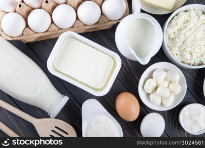 Dairy products on wooden table. Milk, cheese, egg, curd cheese and butter.