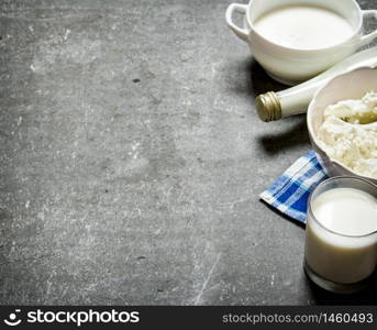 Dairy products. Sour cream, milk and cottage cheese on the napkin. On the stone table.. Sour cream, milk and cottage cheese on the napkin.