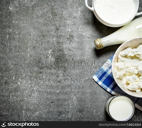 Dairy products. Sour cream, milk and cottage cheese on the napkin. On the stone table.. Sour cream, milk and cottage cheese on the napkin.