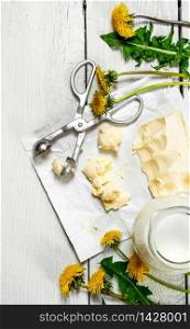 Dairy products with dandelion flowers on white wooden background.. Dairy products with dandelion flowers