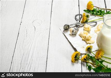 Dairy products with dandelion flowers on white wooden background.. Dairy products with dandelion flowers