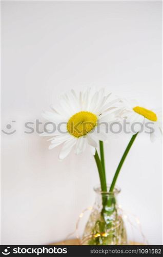 Daisies in vase on a old wooden table. Close-up.. Daisies in vase on a old wooden table