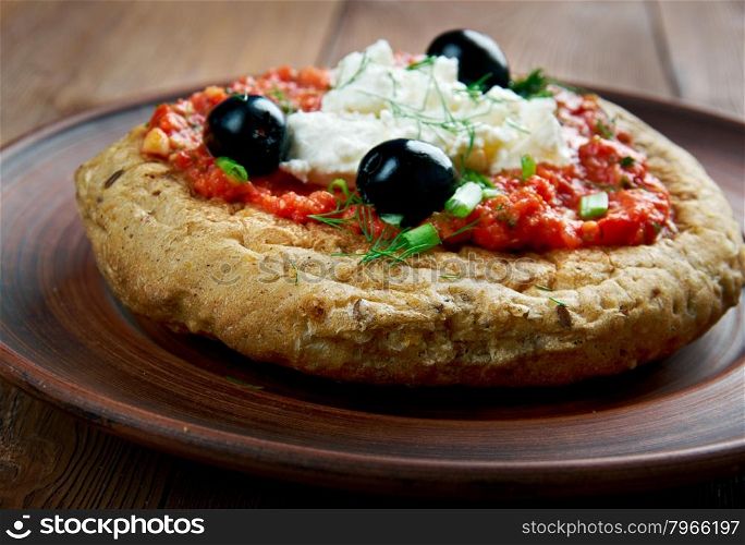 Dakos - slice bread topped with chopped tomatoes and crumbled feta.Cypriot cuisine