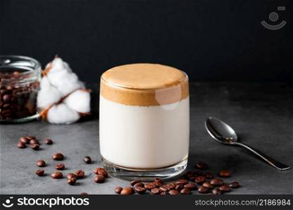 Dalgona coffee on a black background. Making a trendy drink. Fluffy sweet foam in a glass with ice milk.. Dalgona coffee on a black background. Making a trendy drink. Fluffy sweet foam in a glass with iced milk.