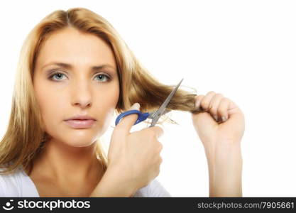 Damaged dry hair splitting ends. Young blonde woman cutting her hair with scissors - unhappy expression, isolated on white background