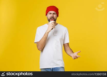 Dance. Handsome young stylish man in headphones holding mobile phone and dancing while standing against yellow background.. Dance. Handsome young stylish man in headphones holding mobile phone and dancing while standing against yellow background