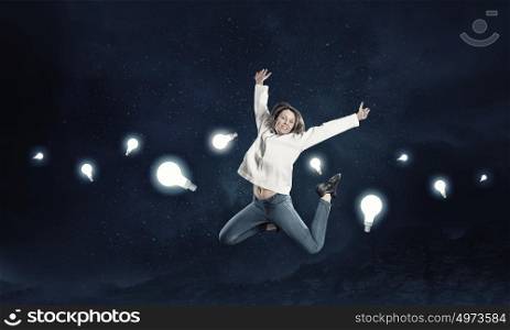 Dancer girl in jump. Young woman dancer jumping among light bulbs on dark background