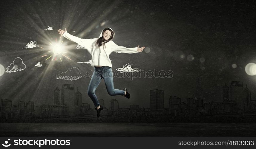 Dancer girl in jump. Young woman dancer jumping in spotlights on dark background