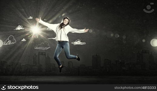 Dancer girl in jump. Young woman dancer jumping in spotlights on dark background