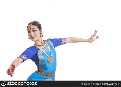 Dancer performing Bharatanatyam against white background