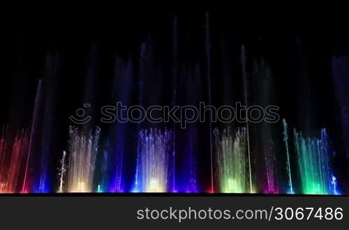 Dancing beautiful colorful fountain. Wide low angle shot.