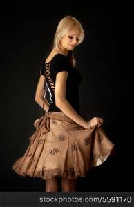dancing blond in brown skirt over black background