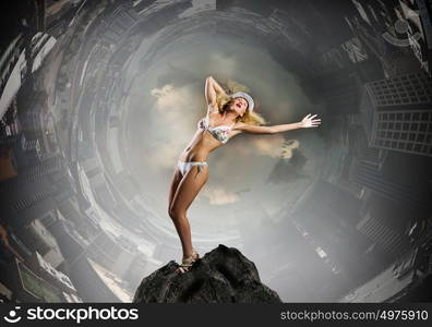 Dancing blonde in bikini. Hot young dancing woman in white bikini on dark background