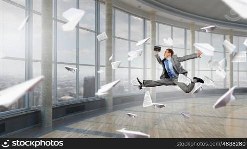 Dancing businessman in office. Young dancing businessman in suit in modern interior