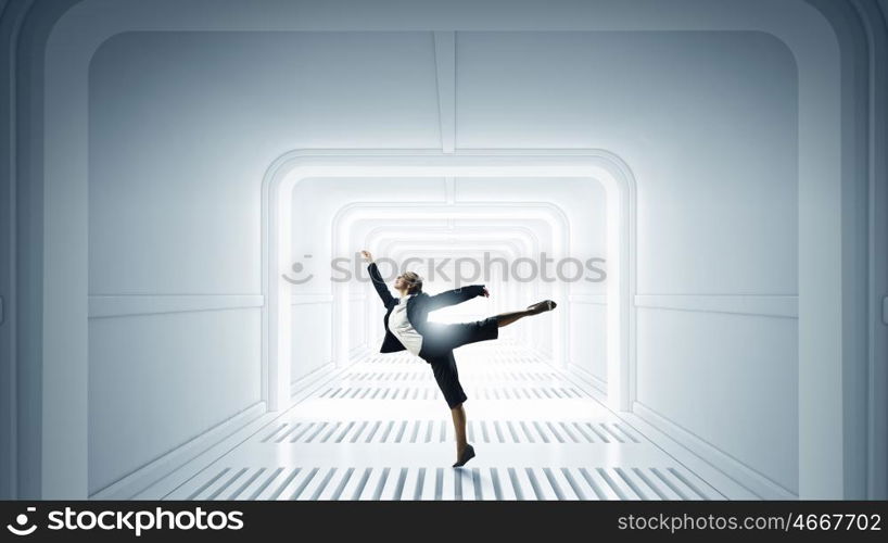 Dancing businesswoman in office. Young dancing businesswoman in suit in futuristic interior