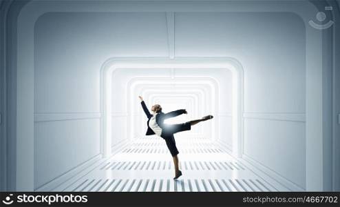 Dancing businesswoman in office. Young dancing businesswoman in suit in futuristic interior