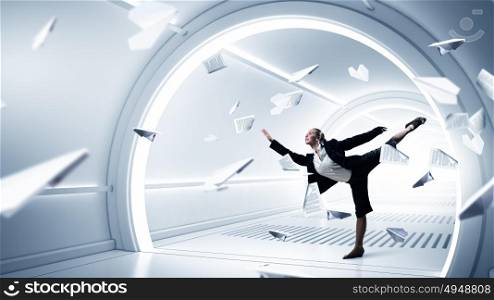 Dancing businesswoman in office. Young dancing businesswoman in suit in futuristic interior