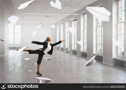 Dancing businesswoman in office. Young dancing businesswoman in suit in modern interior