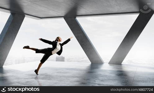 Dancing businesswoman in office. Young dancing businesswoman in suit in modern interior