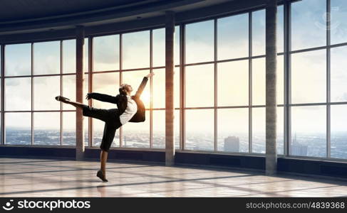 Dancing businesswoman in office. Young dancing businesswoman in suit in modern interior