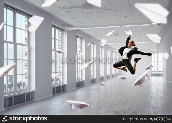Dancing businesswoman in office. Young dancing businesswoman in suit in modern interior
