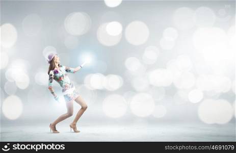 Dancing woman. Young woman in colored dress and hat dancing against bokeh background