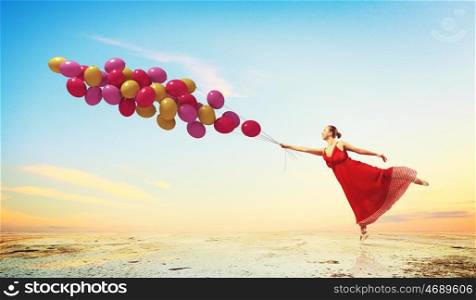 Dancing woman. Young woman in dress and ballerinas dancing with colorful balloons