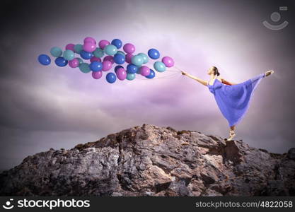 Dancing woman. Young woman in dress and ballerinas dancing with colorful balloons