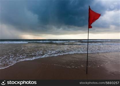 Danger concept background - severe storm warning flags on beach. Baga, Goa, India