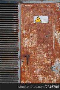 danger high voltage sign on a rusty metal door