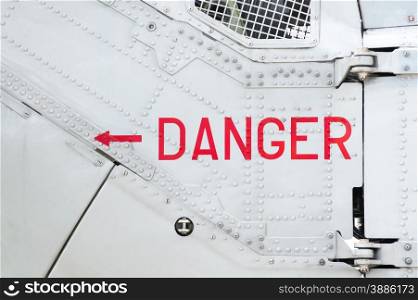 danger sign on the side of a riveted aircraft fuselage