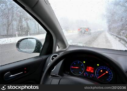 Dangerous winter season with snow on the road. The interior of the car from the driver&rsquo;s point of view - dangerous traffic in bad weather.
