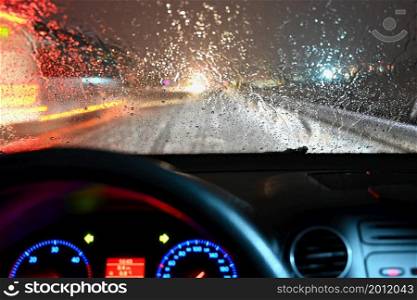 Dangerous winter season with snow on the road. The interior of the car from the driver&rsquo;s point of view - dangerous evening traffic in bad weather.