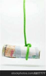 Dangling Singapore dollar held by a rope